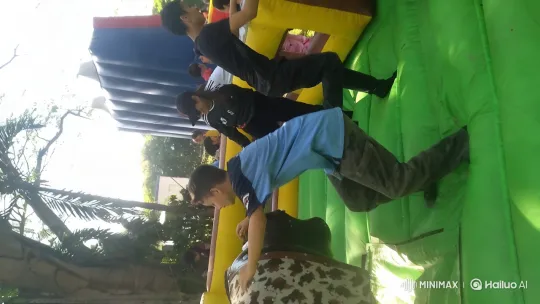 Children Enjoying Mechanical Bull Ride in Vibrant Outdoor Amusement Area – AI Generated Video | Hailuo AI