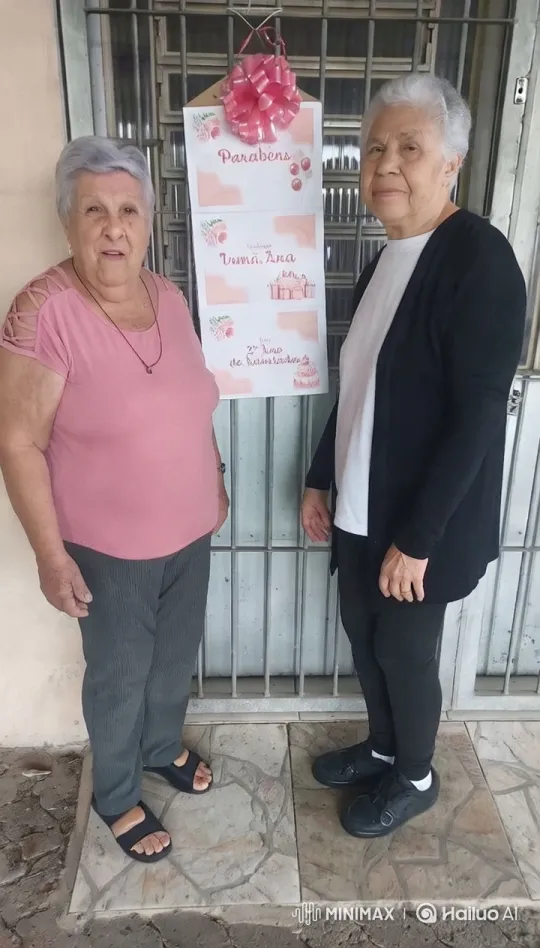 Elderly Women Celebrate with Embrace at Festive Gate – AI Generated Video | Hailuo AI