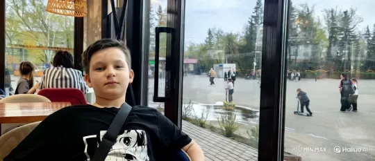 Young Boy Receives Affection in Bustling Café – AI Generated Video | Hailuo AI