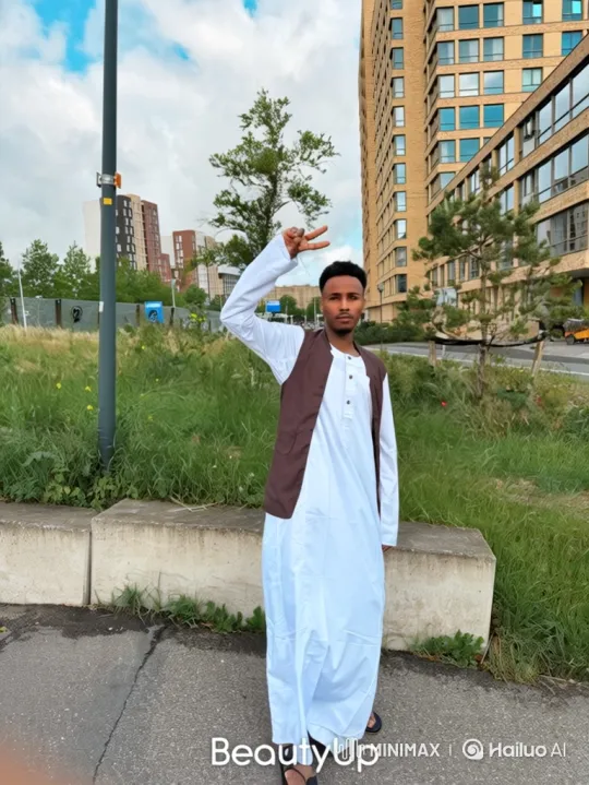 Young Man in Robe Stands Peacefully by Building – AI Generated Video | Hailuo AI