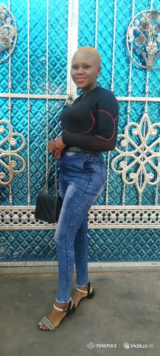 Woman Poses in Front of Blue Gate with Subtle Movements – AI Generated Video | Hailuo AI