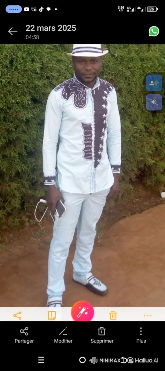 Man in Blue Embroidered Suit Stands Out in Green Hedge Setting – AI Generated Video | Hailuo AI