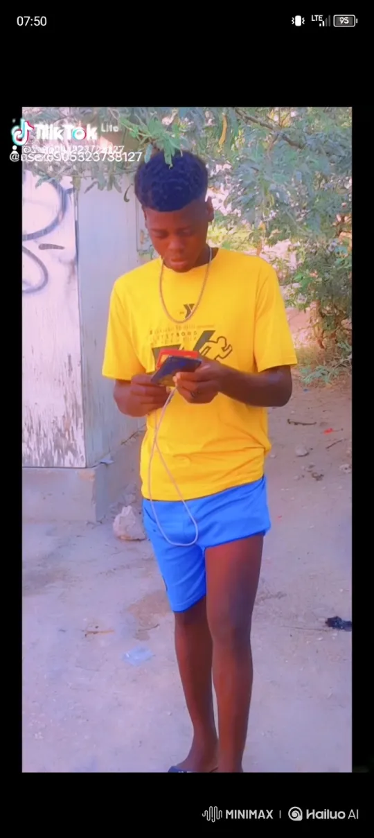 Young Man Engaged with Device in Outdoor Setting – AI Generated Video | Hailuo AI