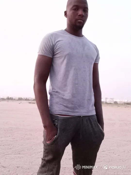 Man Smiles Gently in Open Sandy Landscape – AI Generated Video | Hailuo AI