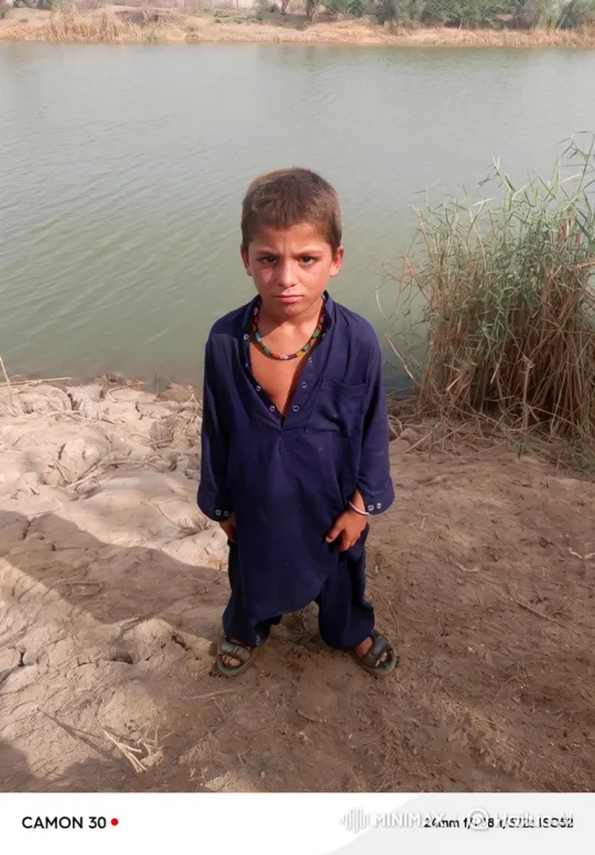 Young Boy Stands by Water, Holding Steady Gaze – AI Generated Video | Hailuo AI