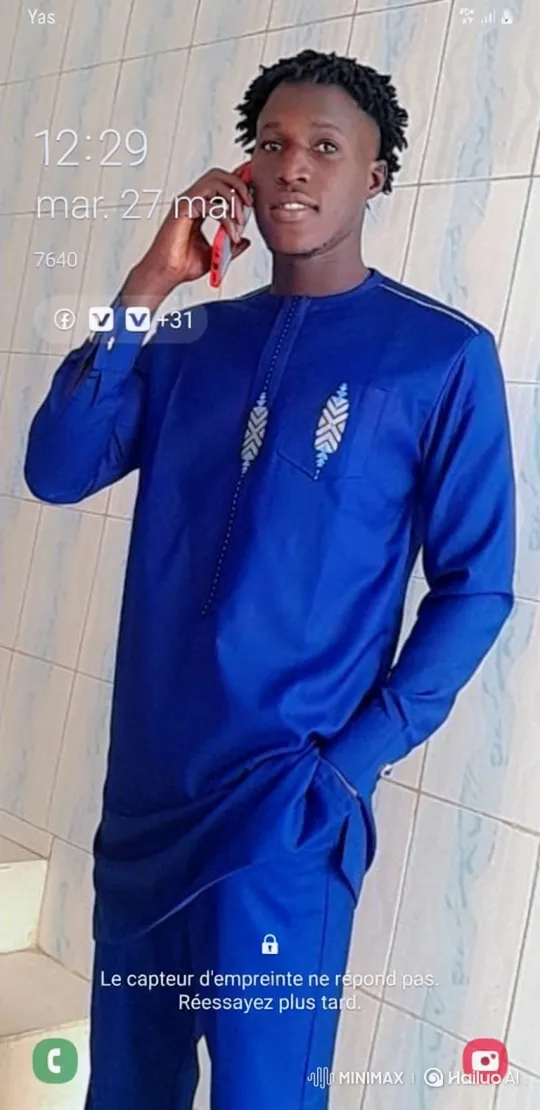 Young Man in Traditional Blue Outfit on Phone – AI Generated Video | Hailuo AI