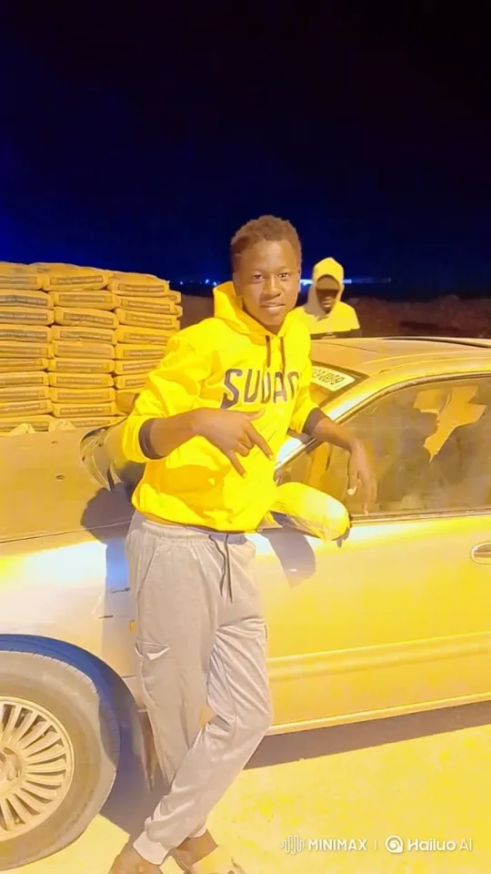 Young Man in Yellow Hoodie Walks Past Car at Night – AI Generated Video | Hailuo AI