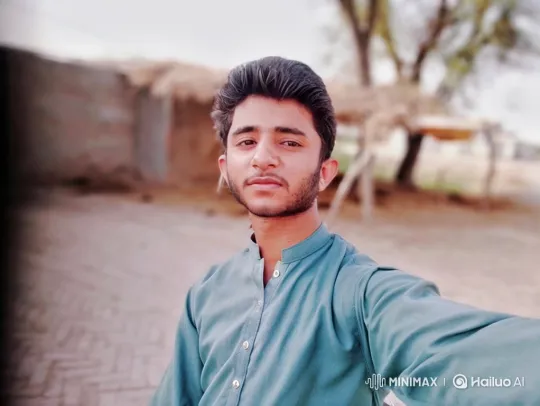 Young Man in Teal Shirt Smiles Gently Outdoors – AI Generated Video | Hailuo AI