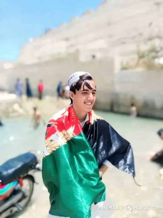Young Man by Water in Vibrant Flag with Scenic Backdrop – AI Generated Video | Hailuo AI