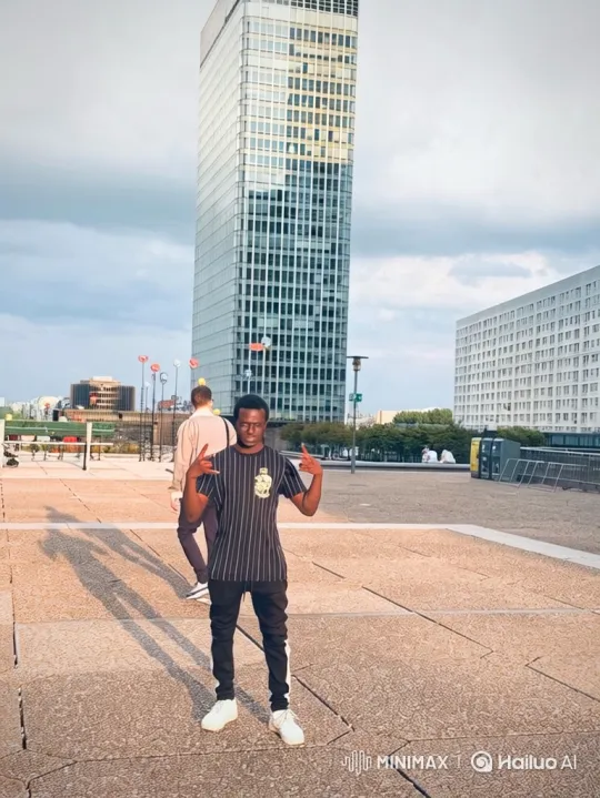 Young Man Poses in Modern City Plaza Amid Skyscrapers – AI Generated Video | Hailuo AI