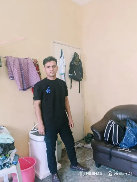 Man in Black Shirt Smiles Gently in Room – AI Generated Video | Hailuo AI