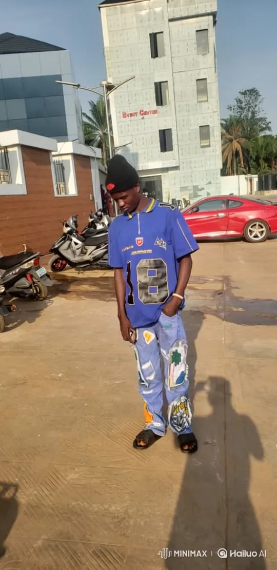 Young Man in Blue Jersey Walks Through Paved Lot – AI Generated Video | Hailuo AI