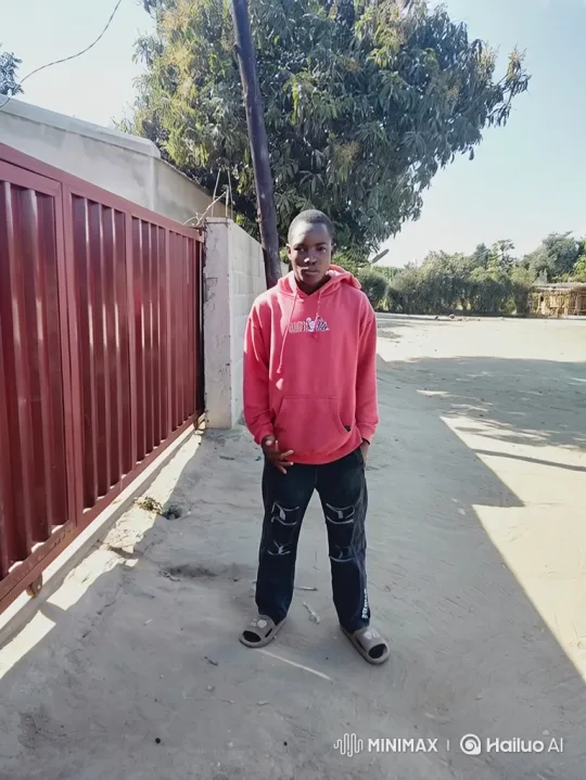 Young Man Stands Confidently by Maroon Gate – AI Generated Video | Hailuo AI