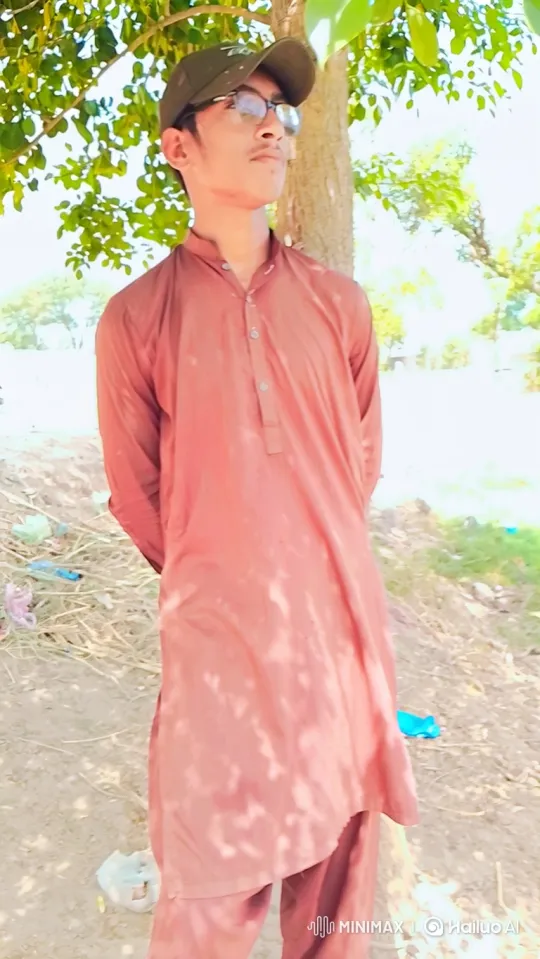 Young Man in Thoughtful Pose Under Swaying Tree – AI Generated Video | Hailuo AI