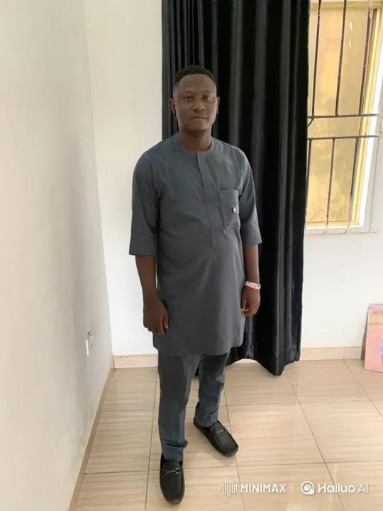 Man in Grey Attire Stands Calmly with a Gentle Smile – AI Generated Video | Hailuo AI