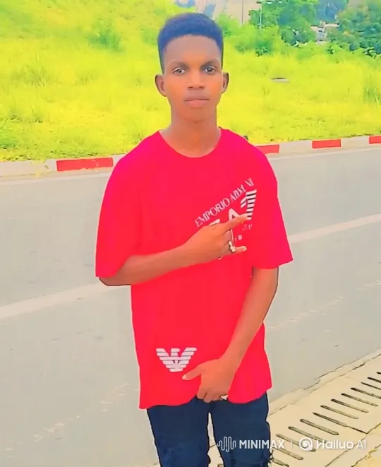 Young Man in Red Shirt Stands Still, Smiles Slightly – AI Generated Video | Hailuo AI