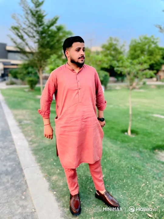 Young Man in Salmon-Pink Outfit Contemplates in Park – AI Generated Video | Hailuo AI