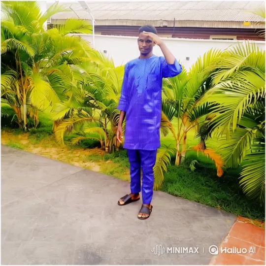 Young Man Salutes in Vibrant Blue Outfit Amidst Palms – AI Generated Video | Hailuo AI