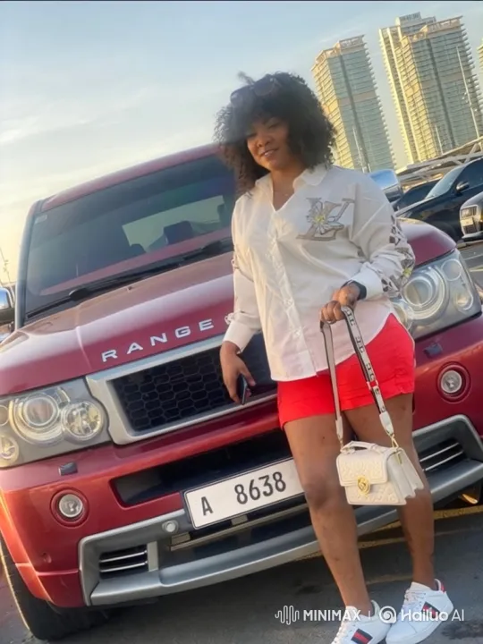 Stylish Woman Departs in Red Range Rover Against City Skyline – AI Generated Video | Hailuo AI