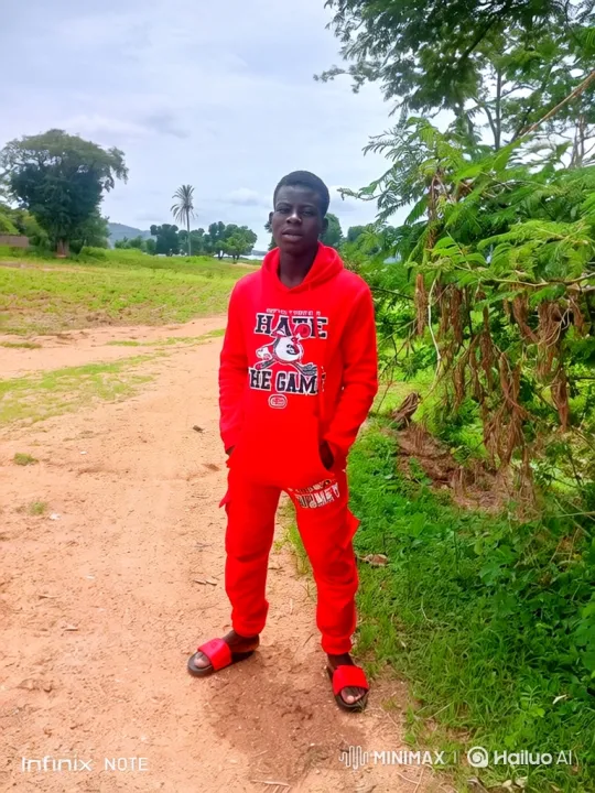 Young Man in Red Tracksuit Stands Calmly in Rural Setting – AI Generated Video | Hailuo AI