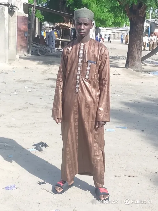 Young Man Stands Calmly in Dusty Street, Breeze and Life Persist – AI Generated Video | Hailuo AI