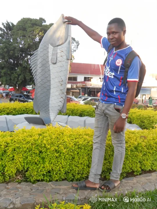 Young Man Poses by Park's Fish Statue – AI Generated Video | Hailuo AI