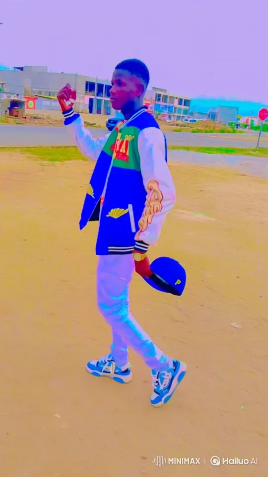 Young Man in Varsity Jacket Walks on Sandy Path – AI Generated Video | Hailuo AI