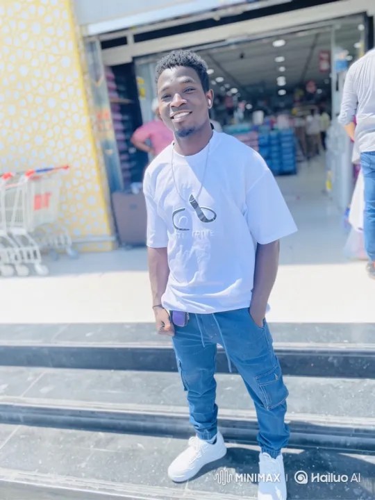 Young Man Smiles Cheerfully on Store Steps – AI Generated Video | Hailuo AI