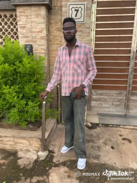 Man in Pink Shirt Examines Stone-Wall House – AI Generated Video | Hailuo AI