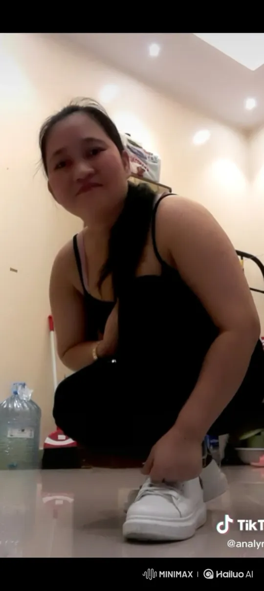 East Asian Woman Ties Shoe Laces and Stands Confidently – AI Generated Video | Hailuo AI