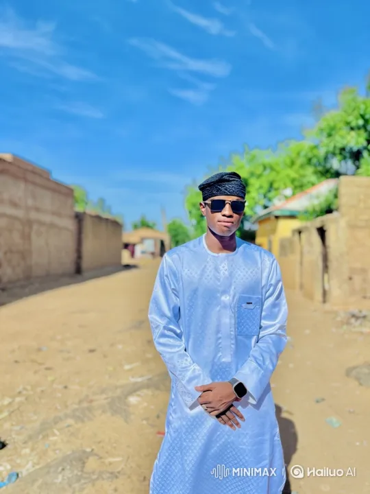 Young Man Stands Thoughtfully in Sunny Village – AI Generated Video | Hailuo AI