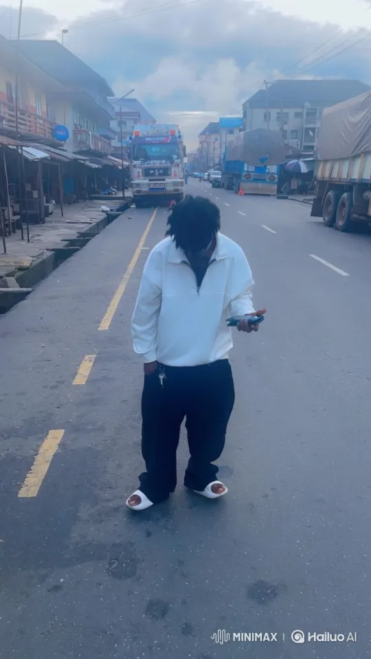 Urban Street Scene: Person Walks, Trucks Move, Camera Tracks – AI Generated Video | Hailuo AI