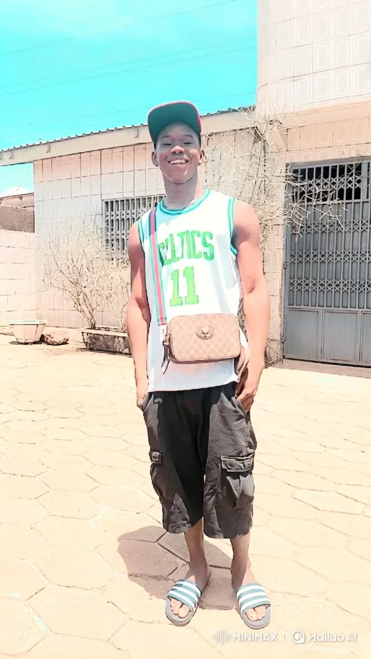 Young Man in Celtics Jersey Smiles in Courtyard – AI Generated Video | Hailuo AI