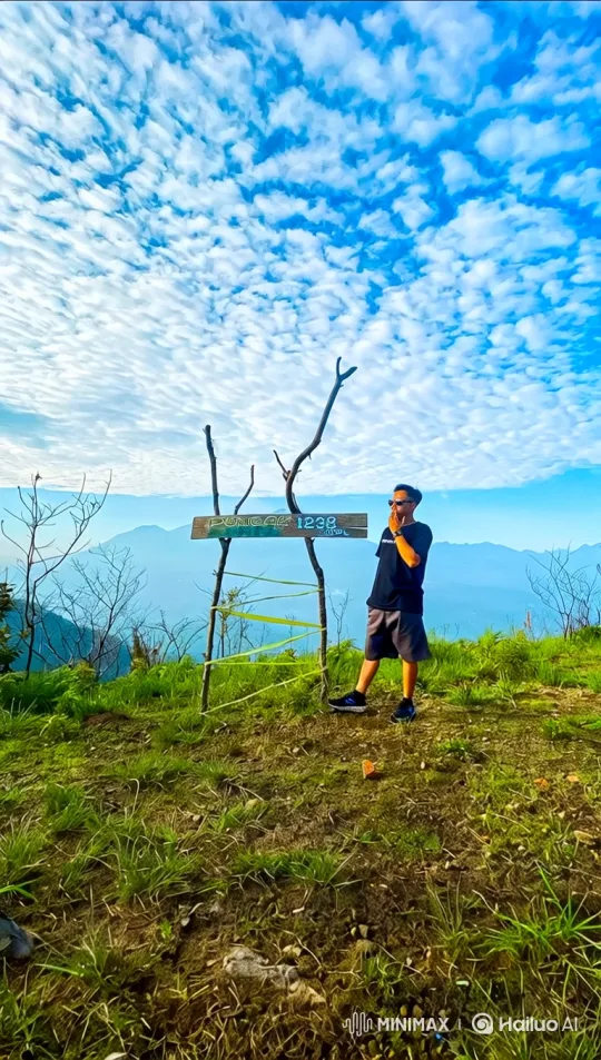 Man Stands Proudly at Mountain Summit with Expansive View – AI Generated Video | Hailuo AI