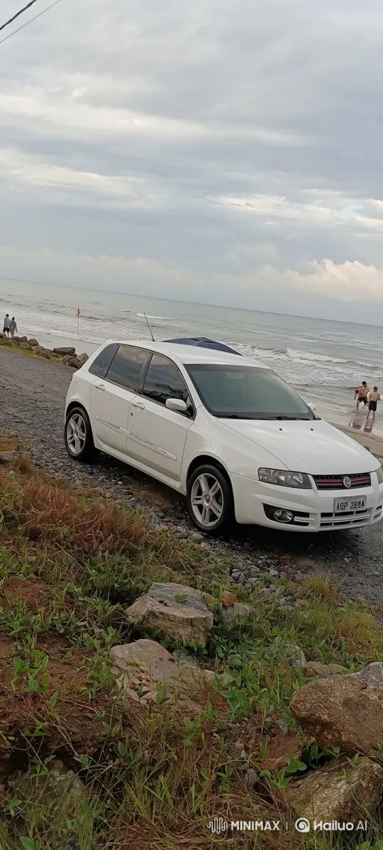 White Hatchback Demonstrates Air Suspension on Beach – AI Generated Video | Hailuo AI