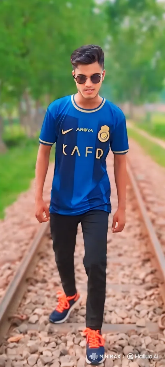 Young Man in Striped Jersey Walks Towards Camera on Train Tracks – AI Generated Video | Hailuo AI