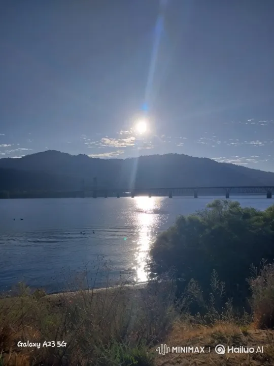Sunlit River Landscape with Bridge and Mountains – AI Generated Video | Hailuo AI