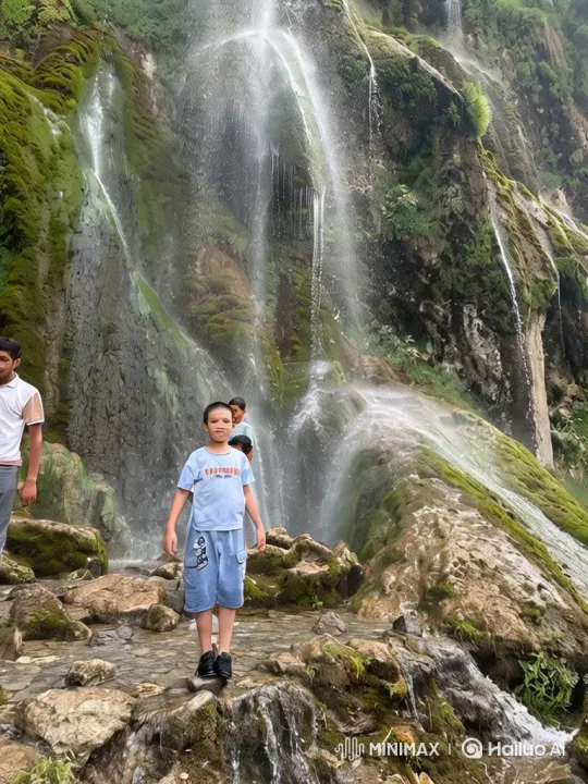 Boy Amidst Majestic Waterfall and Expansive Landscape – AI Generated Video | Hailuo AI