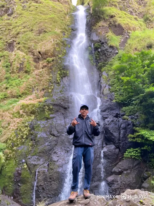 Young Man Celebrates at Base of Majestic Waterfall – AI Generated Video | Hailuo AI