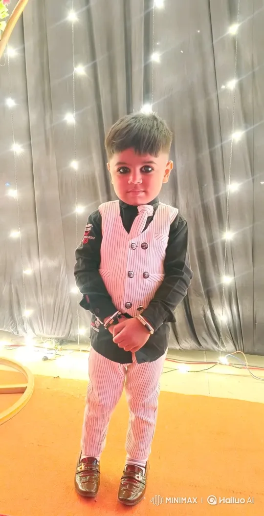 Young Boy Poses in Elegant Outfit Amidst Fairy Lights – AI Generated Video | Hailuo AI