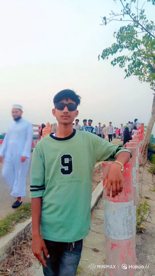 Young Man in Green Shirt Stands Calmly on Walkway – AI Generated Video | Hailuo AI