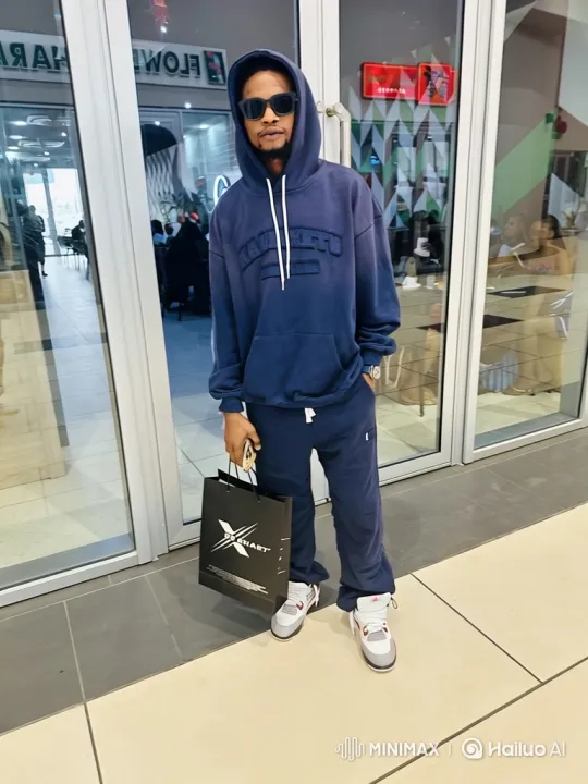 Man in Hoodie Stands Still in Brightly Lit Mall – AI Generated Video | Hailuo AI