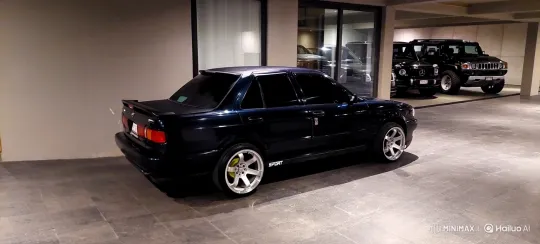 Custom Dark Blue Sedan Lowers on Air Suspension in Modern Garage – AI Generated Video | Hailuo AI