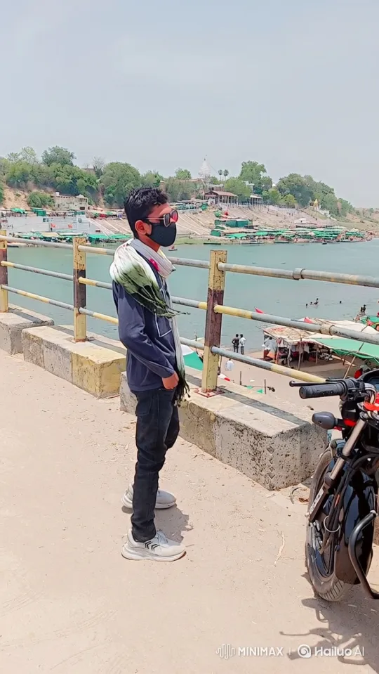 Young Man on Bridge Observes Riverbank Activity – AI Generated Video | Hailuo AI