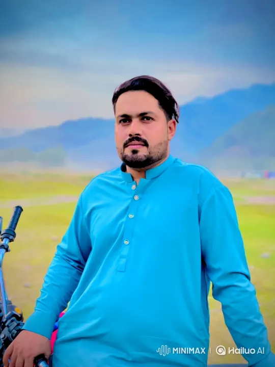 Man in Blue Tunic Smiles Gently in Serene Landscape – AI Generated Video | Hailuo AI