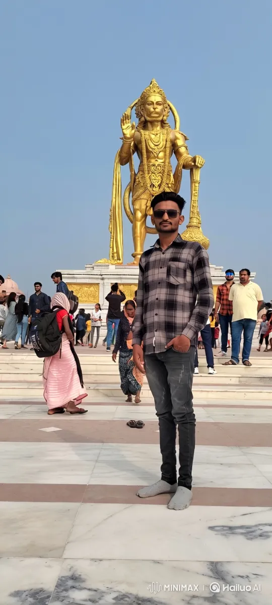 Young Man Poses in Plaza with Golden Statue Background – AI Generated Video | Hailuo AI