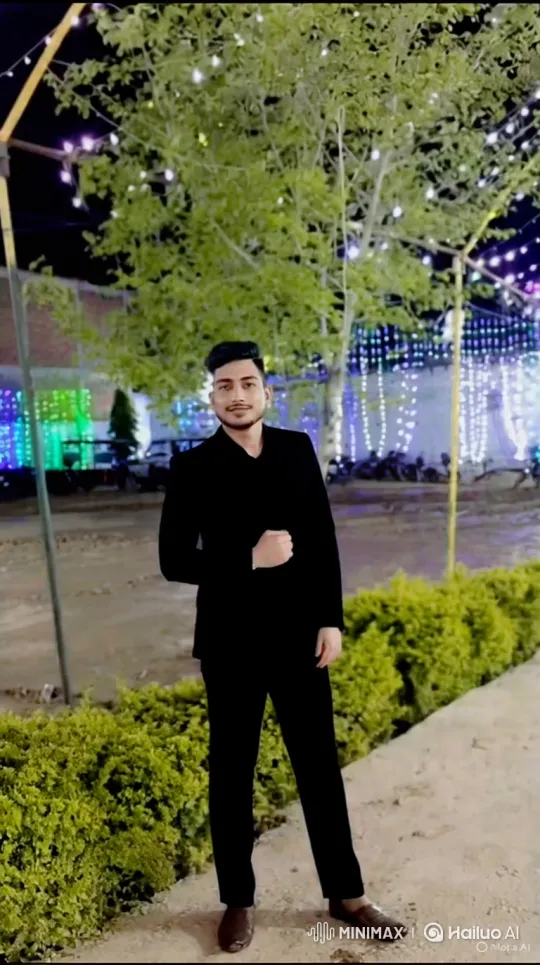 Young Man in Black Suit Under Festive Lights – AI Generated Video | Hailuo AI