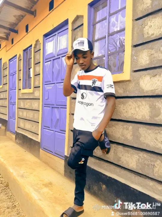 Young Man Walks Alongside a Building in Casual Attire – AI Generated Video | Hailuo AI