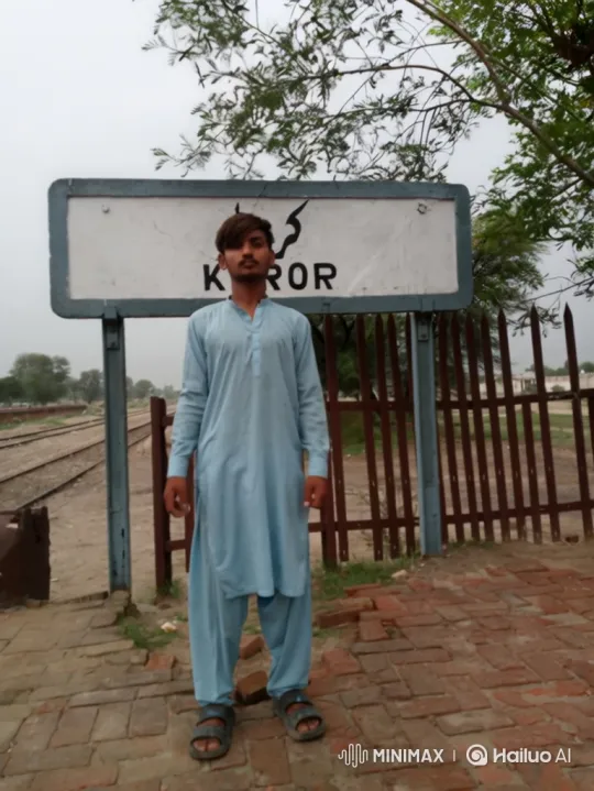 Young Man in Traditional Attire at Rural Train Station – AI Generated Video | Hailuo AI
