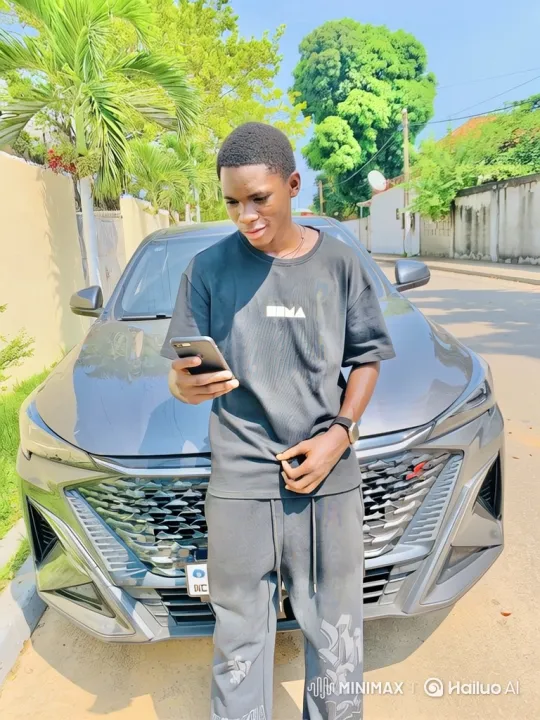 Young Black Man Smiles, Engages with Phone Outdoors – AI Generated Video | Hailuo AI